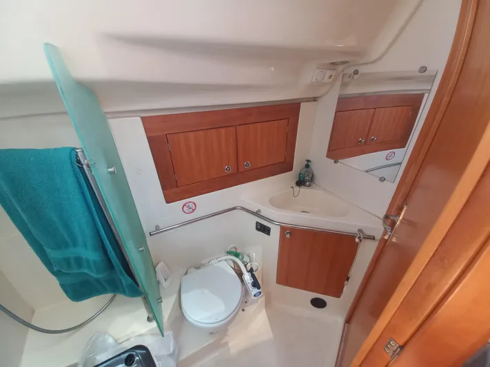 Yacht Photos Pics 2005 Elan Impression 434 yacht bathroom with wooden cabinets and a compact toilet.