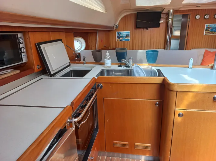  Yacht Photos Pics Interior of 2005 Elan Impression 434 yacht kitchen with wood finish and modern appliances.