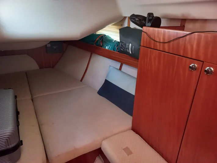  Yacht Photos Pics Cozy cabin interior of 2005 Elan Impression 434 sailboat with wooden cabinetry and cushioned seating.