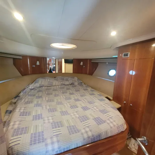  Yacht Photos Pics Luxurious cabin interior of 2006 Cranchi Mediterranee 47 HT yacht with cozy bed and wooden finish.