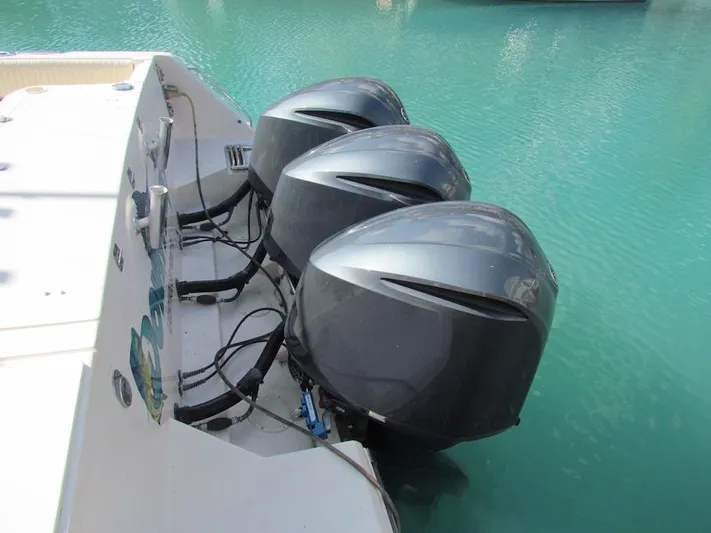  Yacht Photos Pics Triple outboard motors on a 2008 Grady-White Express 360 in turquoise water.