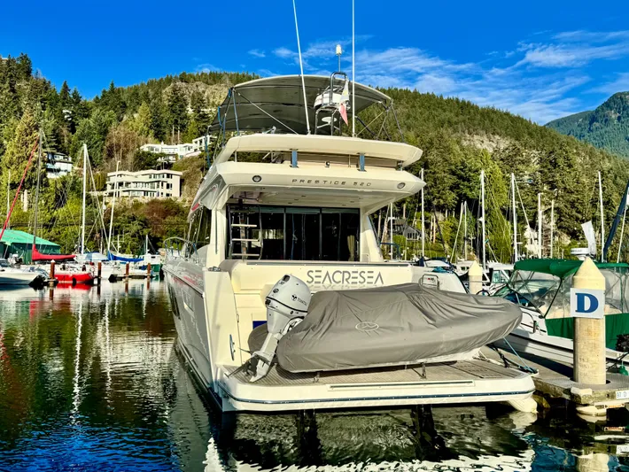 Seacresea Yacht Photos Pics Prestige 520 yacht docked in scenic marina, surrounded by lush hills and clear blue sky.