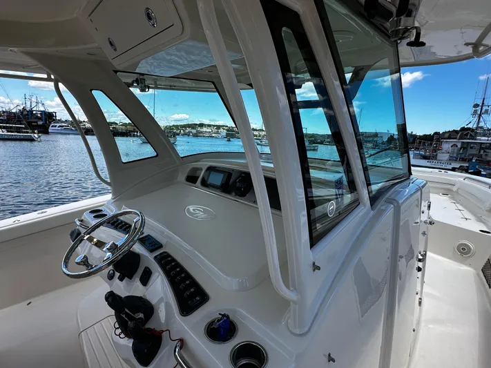 Katy Lady Yacht Photos Pics 2017 Grady-White Canyon 376 boat interior with steering wheel and control panel, docked at marina.