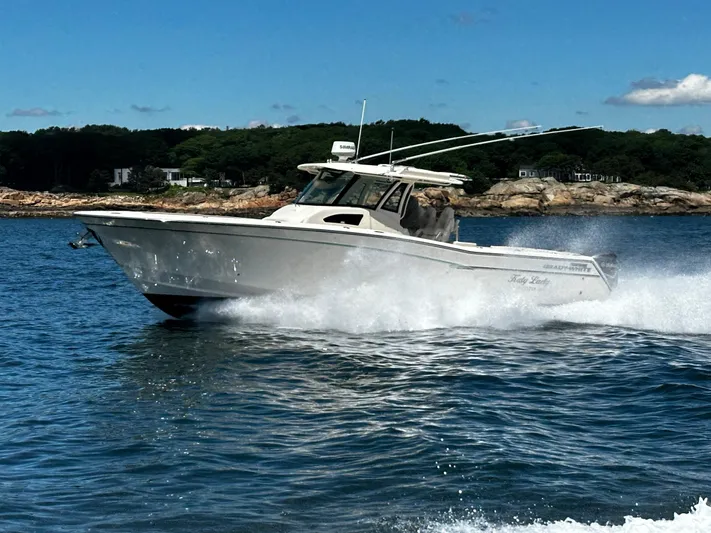 Katy Lady Yacht Photos Pics 2017 Grady-White Canyon 376 boat cruising on water near rocky shoreline.