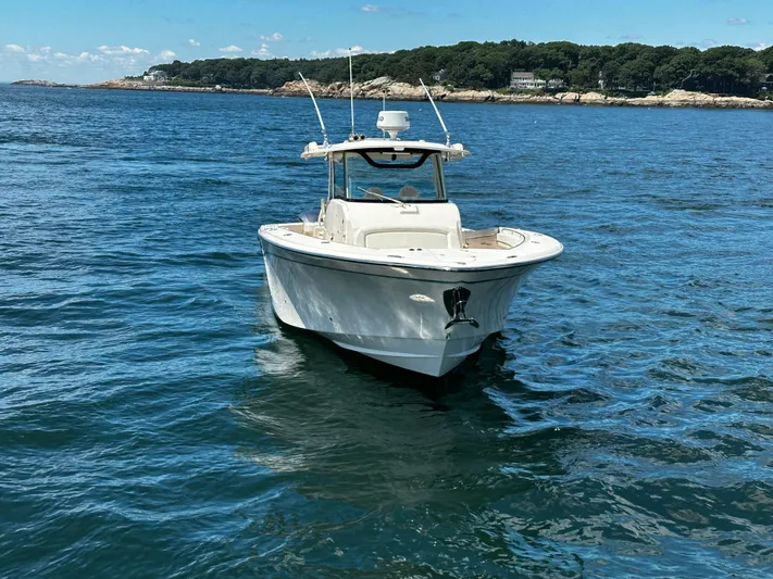 Katy Lady Yacht Photos Pics 2017 Grady-White Canyon 376 boat on calm blue water near a forested shoreline.
