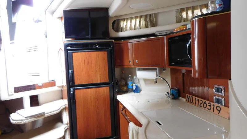 Yacht Photos Pics 2002 Sea Ray 380 Sundancer interior with kitchenette, featuring wood cabinets and modern appliances.