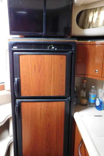  Yacht Photos Pics 2002 Sea Ray 380 Sundancer interior with wood-paneled fridge and TV.