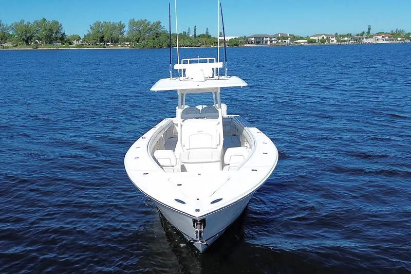 Huddle Up Yacht Photos Pics 2018 Jupiter 38 FS boat on calm blue water, clear sky background.