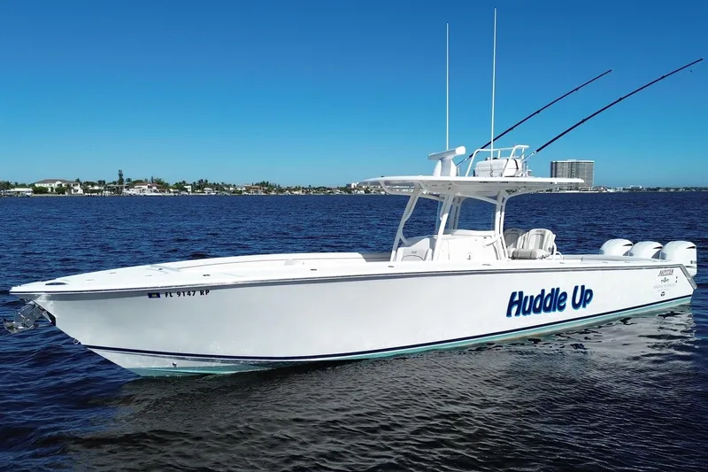 Huddle Up Yacht Photos Pics 2018 Jupiter 38 FS boat named "Huddle Up" on calm water under clear blue sky.