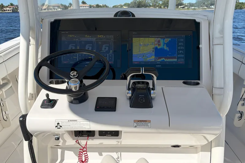Huddle Up Yacht Photos Pics 2018 Jupiter 38 FS boat helm with steering wheel, dual screens, and control panel.