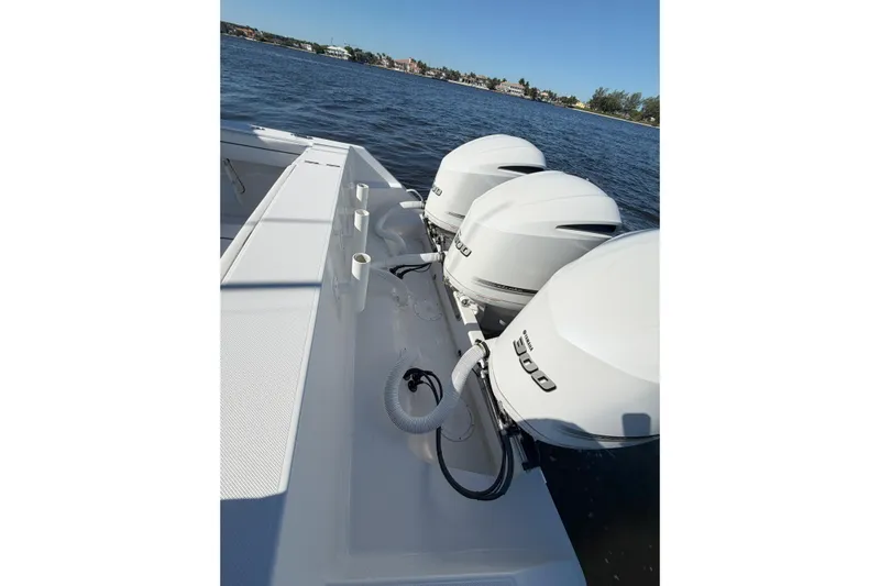 Huddle Up Yacht Photos Pics 2018 Jupiter 38 FS boat with triple outboard engines on a sunny day.