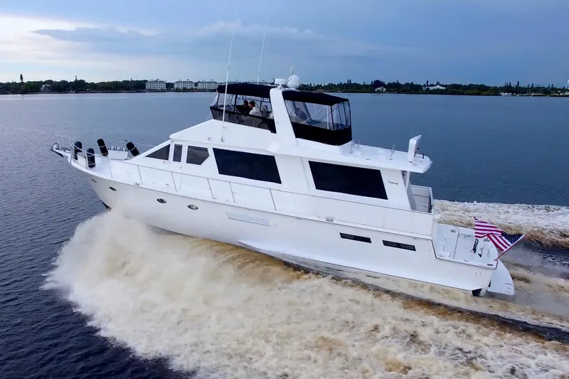 Cleodora Yacht Photos Pics 1988 Viking 63 Cockpit Motor Yacht cruising on open water, American flag displayed.
