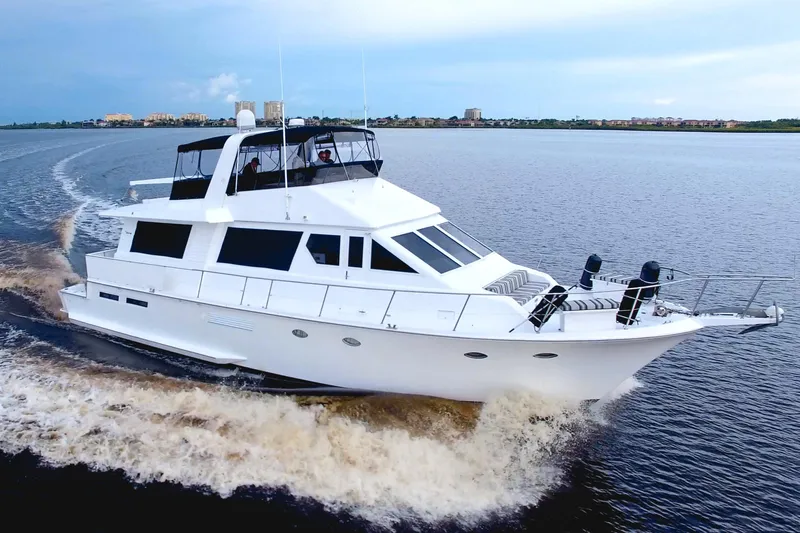 Cleodora Yacht Photos Pics 1988 Viking 63 Cockpit Motor Yacht cruising on open water, showcasing sleek design and luxury.