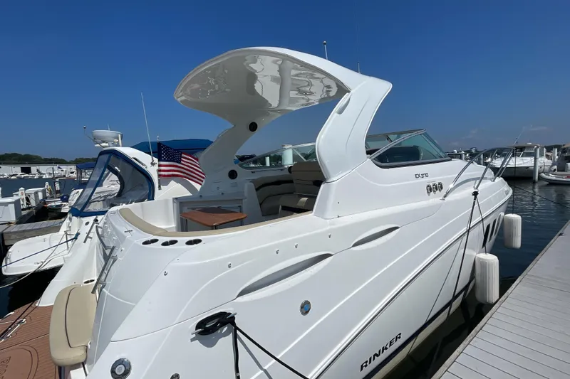  Yacht Photos Pics 2017 Rinker EX 370 yacht docked at marina, featuring sleek white design and American flag.
