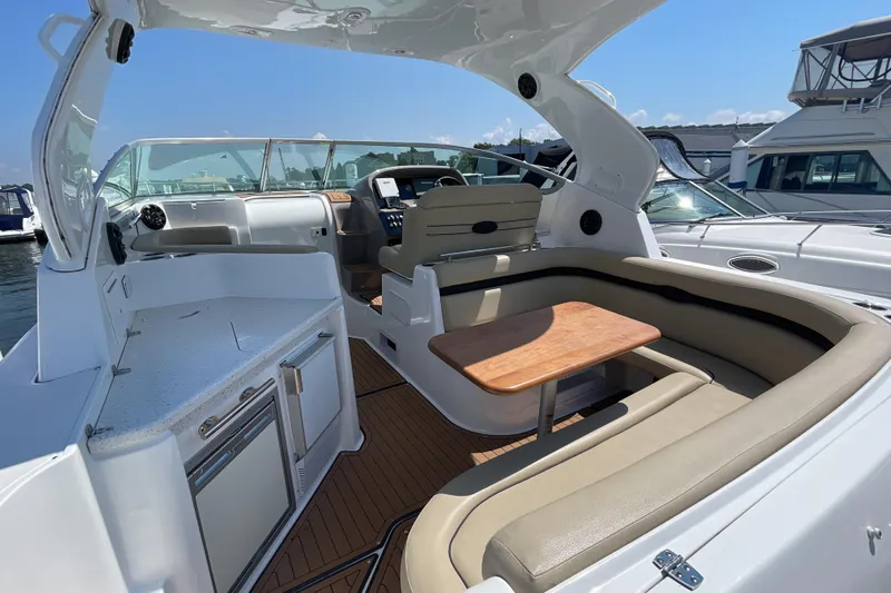 Yacht Photos Pics 2017 Rinker EX 370 boat interior with seating, table, and helm in a marina setting.
