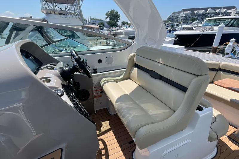  Yacht Photos Pics 2017 Rinker EX 370 boat interior with beige seating and helm, docked at marina.