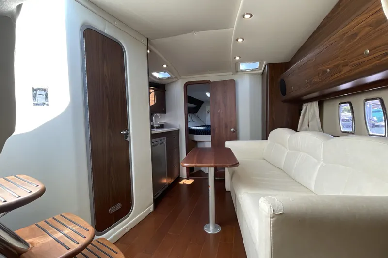  Yacht Photos Pics Interior of 2017 Rinker EX 370 yacht with sofa, table, and kitchenette.