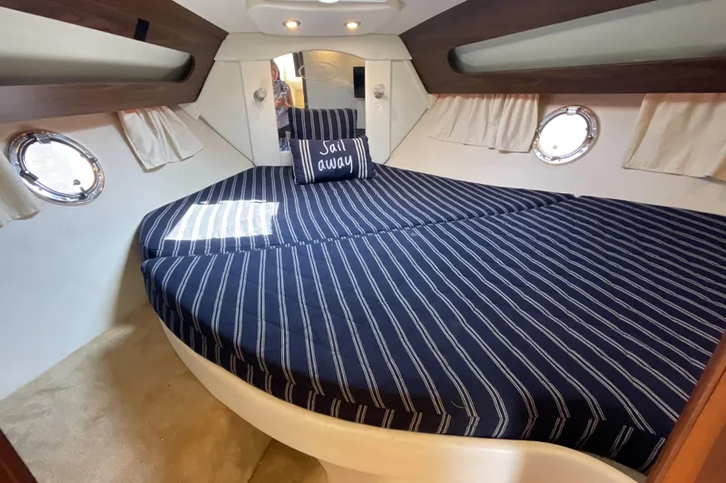  Yacht Photos Pics 2017 Rinker EX 370 cabin interior with striped bedding and "Sail away" pillow.