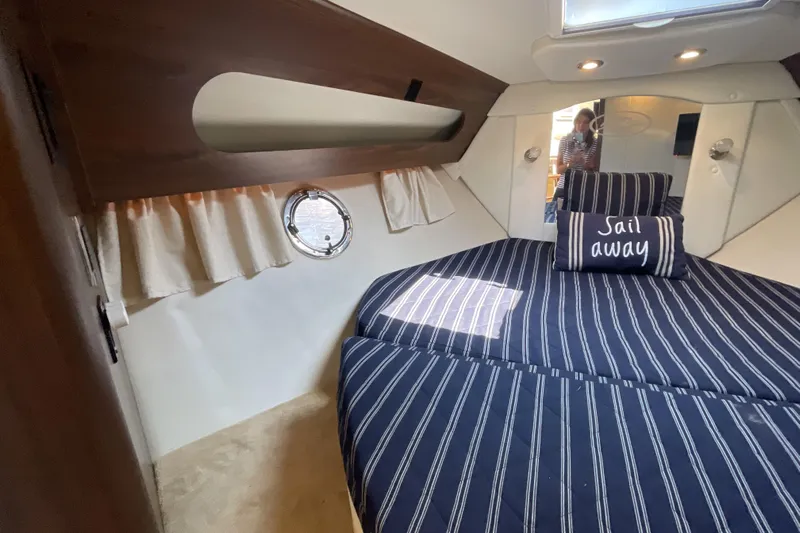 Yacht Photos Pics 2017 Rinker EX 370 cabin interior with striped bedding and "Sail Away" pillow.