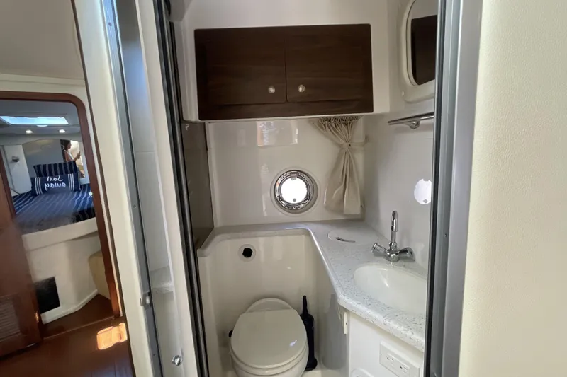  Yacht Photos Pics 2017 Rinker EX 370 boat bathroom with sink, toilet, and porthole window.