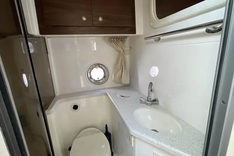  Yacht Photos Pics 2017 Rinker EX 370 boat bathroom with sink, toilet, and porthole window.