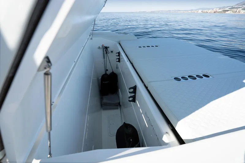  Yacht Photos Pics 2026 De Antonio Yachts D50 storage compartment with open hatch, overlooking calm sea.