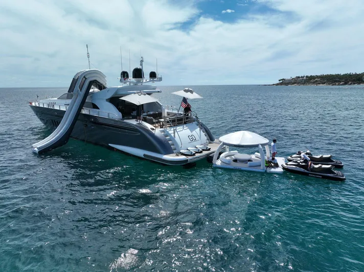 Go Yacht Photos Pics Luxury Leopard 34 yacht with slide, jet skis, and floating lounge on open sea.