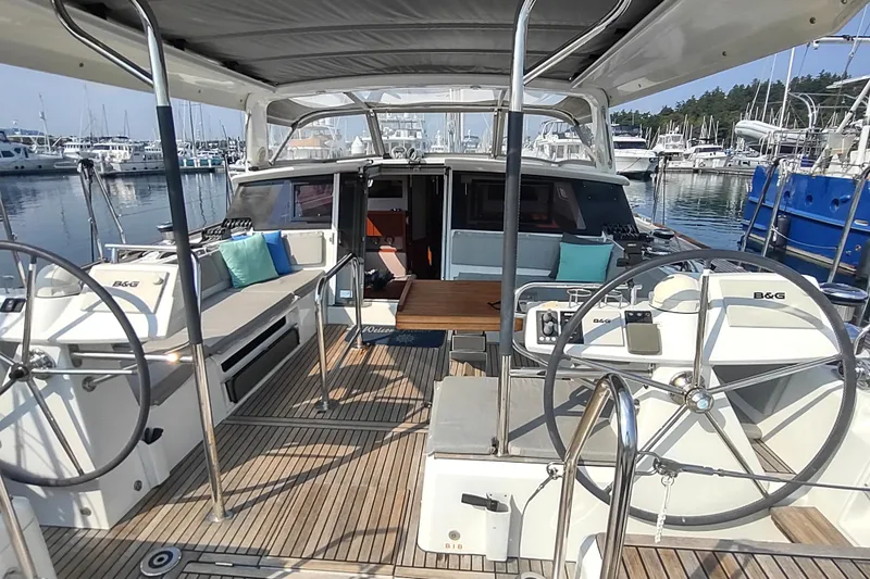 Indigo Sea Yacht Photos Pics 2018 Beneteau Sense 57 yacht cockpit with dual steering wheels and marina view.