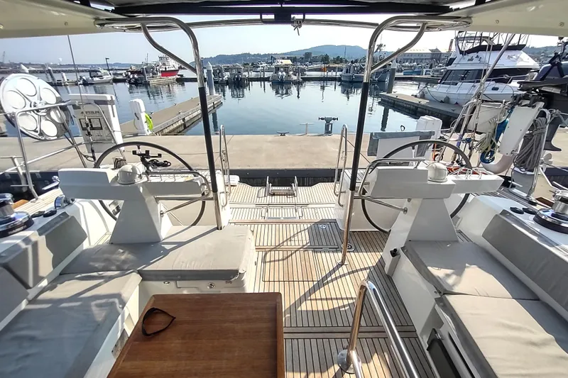 Indigo Sea Yacht Photos Pics 2018 Beneteau Sense 57 yacht cockpit with dual steering wheels, docked at marina.