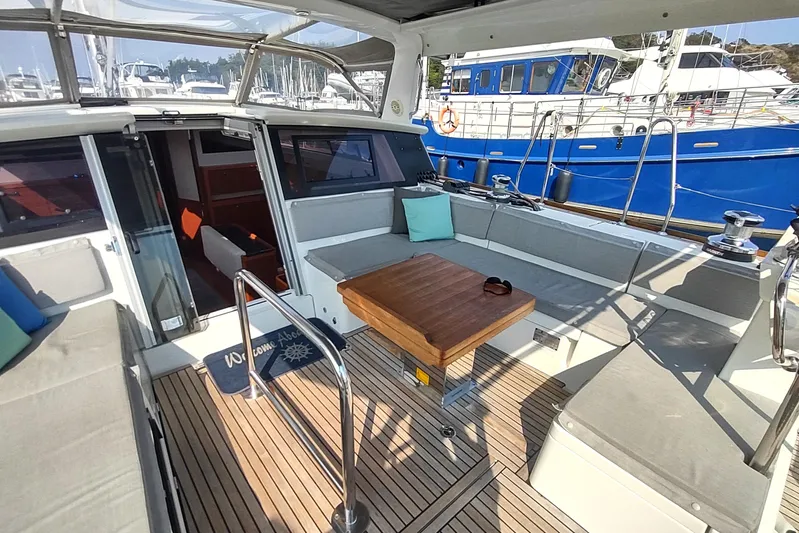 Indigo Sea Yacht Photos Pics 2018 Beneteau Sense 57 yacht cockpit with seating, table, and marina view.
