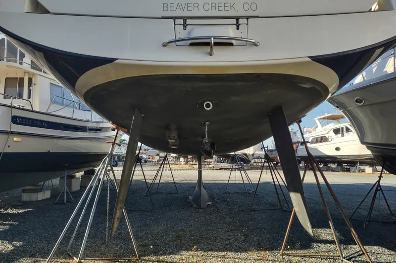 Indigo Sea Yacht Photos Pics 2018 Beneteau Sense 57 sailboat on stands, viewed from below, in a marina.