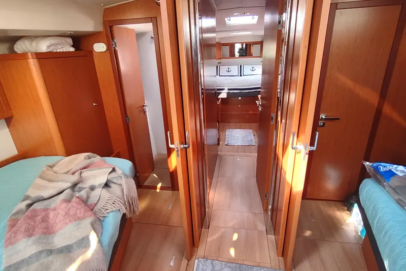 Indigo Sea Yacht Photos Pics Interior of 2018 Beneteau Sense 57 yacht, featuring cozy wooden cabin and bedding.