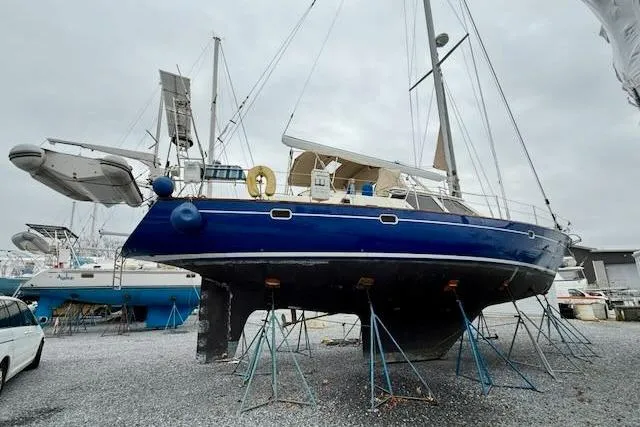 Mavi Yacht Photos Pics 1991 Oyster 49 sailboat on stands in a boatyard, overcast sky.