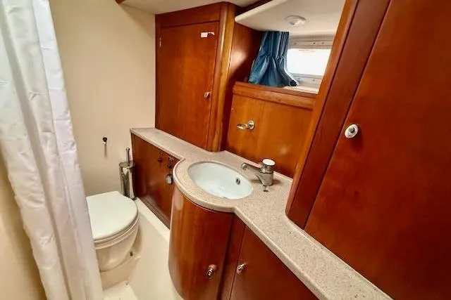 Mavi Yacht Photos Pics Luxurious 1991 Oyster 49 yacht bathroom with wooden cabinetry and modern fixtures.