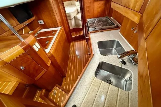 Mavi Yacht Photos Pics Luxurious 1991 Oyster 49 yacht interior with wooden cabinetry and dual kitchen sinks.
