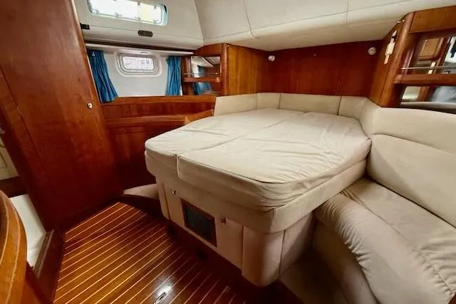 Mavi Yacht Photos Pics Interior of a 1991 Oyster 49 yacht with cozy wooden furnishings and a comfortable bed.