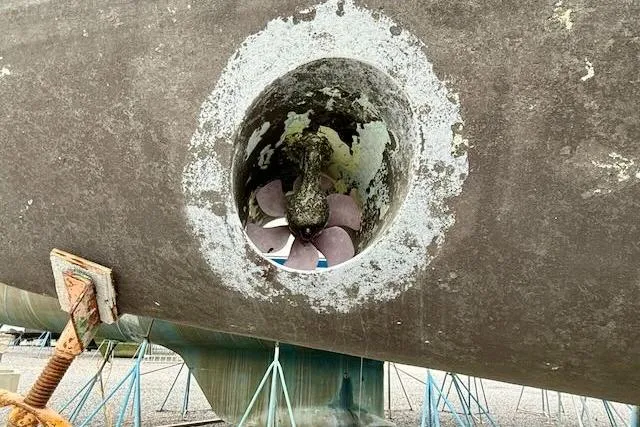 Mavi Yacht Photos Pics Propeller of 1991 Oyster 49 sailboat on dry dock, showing hull and support stands.