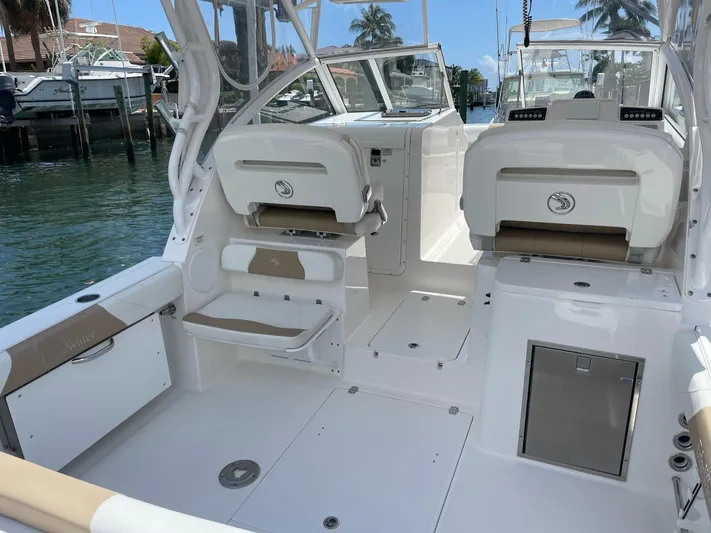  Yacht Photos Pics 2017 Edgewater 280 CX boat interior with seating and storage, docked by the water.