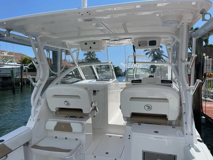  Yacht Photos Pics 2017 Edgewater 280 CX boat interior with seating, docked by the water.