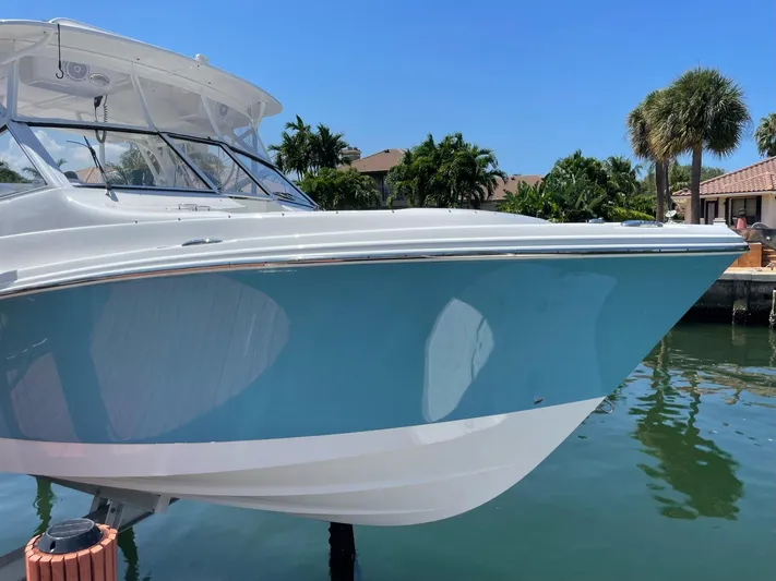  Yacht Photos Pics Edgewater 280 CX 2017 boat docked, featuring sleek blue and white design.