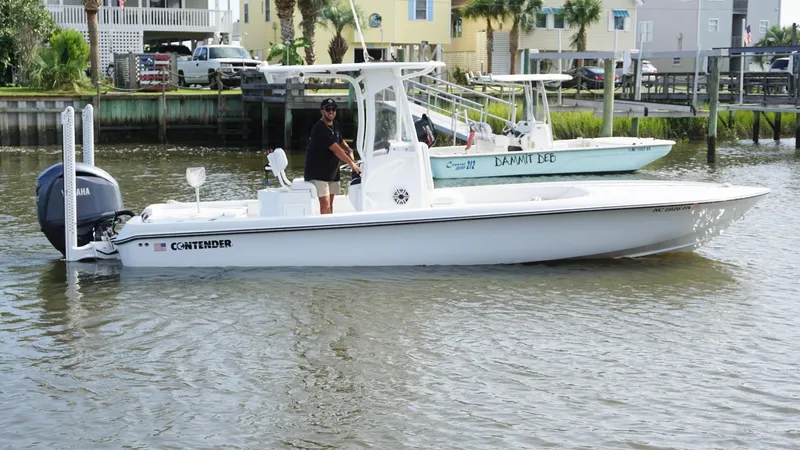 Yacht Photos Pics 2023 Contender 26 Bay boat on calm water near docks and houses.