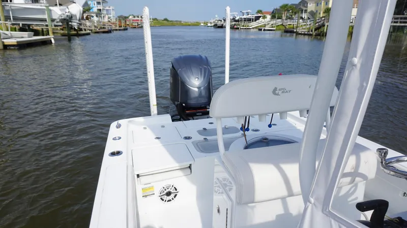  Yacht Photos Pics 2023 Contender 26 Bay boat on a calm waterway, featuring a sleek design and modern outboard motor.