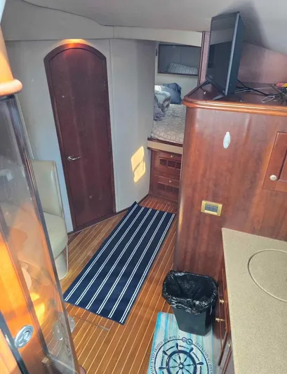 No Interruptions Yacht Photos Pics Interior of 2000 Rampage 38 Express boat with wood finish and striped rug.