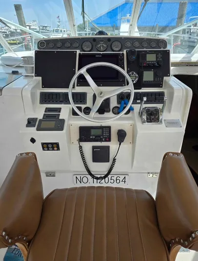 No Interruptions Yacht Photos Pics Cockpit of 2000 Rampage 38 Express boat with steering wheel and navigation instruments.