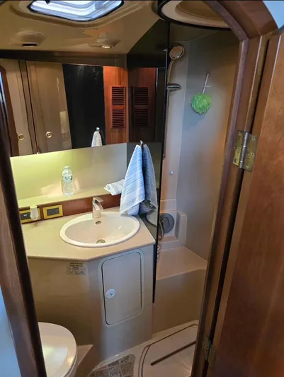 No Interruptions Yacht Photos Pics 2000 Rampage 38 Express boat bathroom with sink, mirror, and shower area.