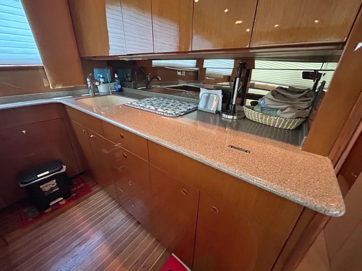  Yacht Photos Pics Luxurious kitchen interior of a 2004 Viking 48C yacht with wooden cabinetry and sleek countertops.