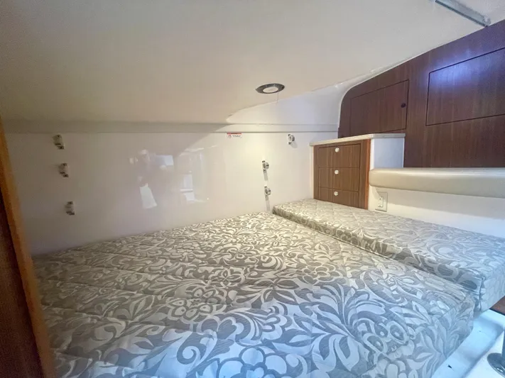 Hobi One Yacht Photos Pics 2015 Pursuit 345 Offshore cabin interior with patterned bedding and wooden storage cabinets.