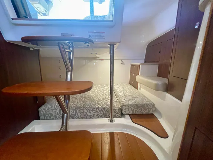Hobi One Yacht Photos Pics 2015 Pursuit 345 Offshore cabin interior with wooden steps and patterned bedding.