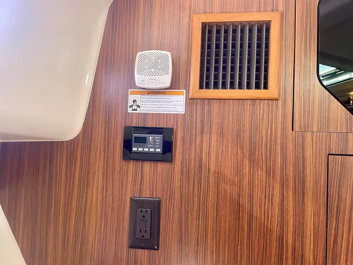 Hobi One Yacht Photos Pics Interior of 2015 Pursuit 345 Offshore boat with wood paneling and electrical outlets.