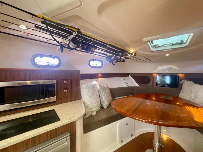 Hobi One Yacht Photos Pics Interior of 2015 Pursuit 345 Offshore boat with kitchen and seating area.